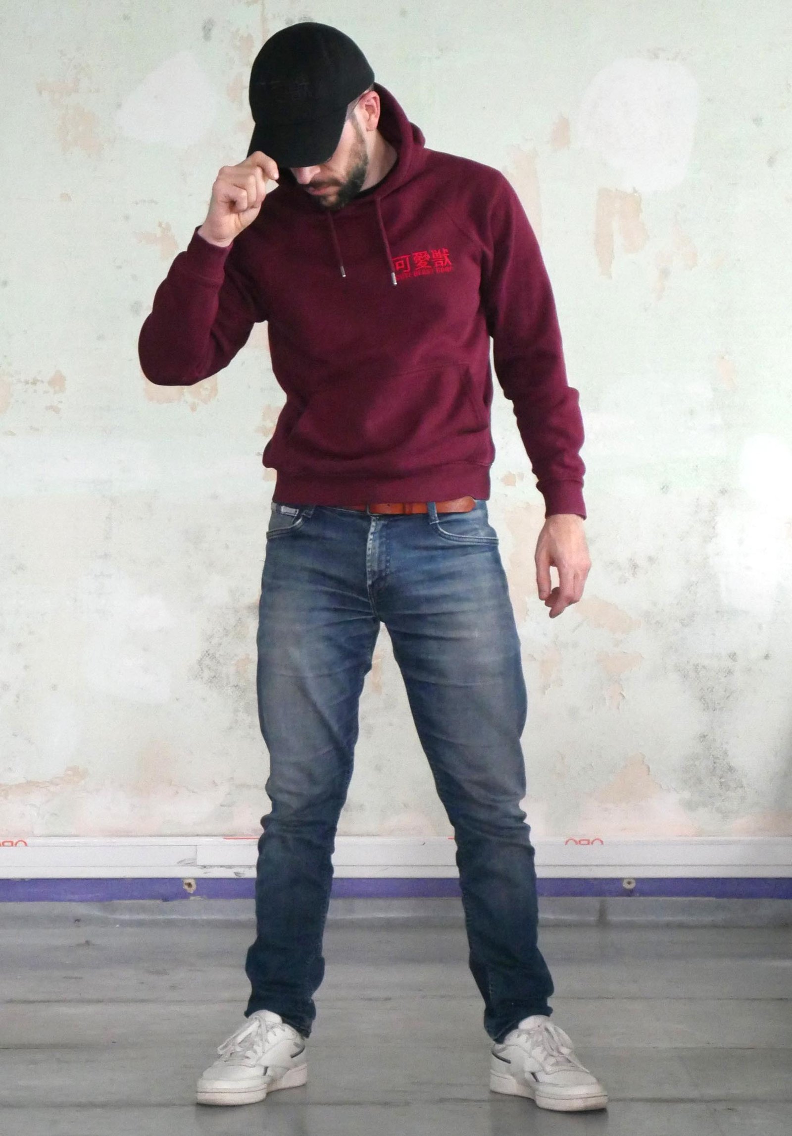 Modèle portant un hoodie bordeau et une casquette noire cute beast corp.
