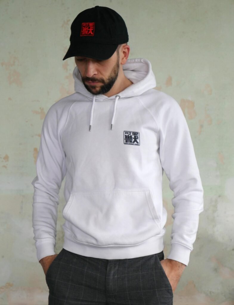 Nicolas, créateur de CUTE BEAST CORP. Portant un sweat et une casquette de la marque.